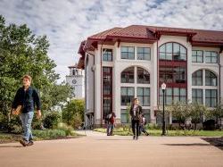 Students walking around campus on a cloudy day.